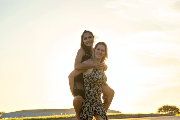 Mother carrying daughter at sunset