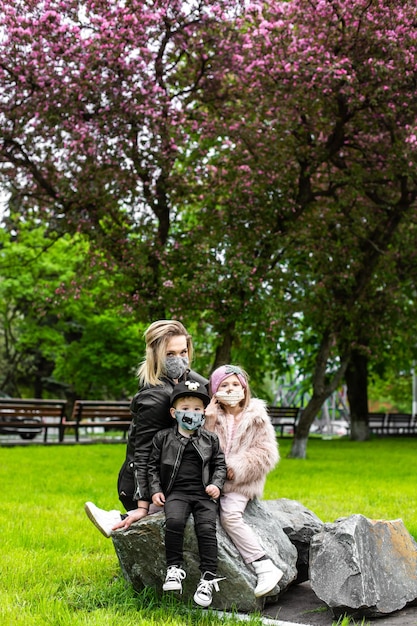 Mother carrying son and daughter as they play in park