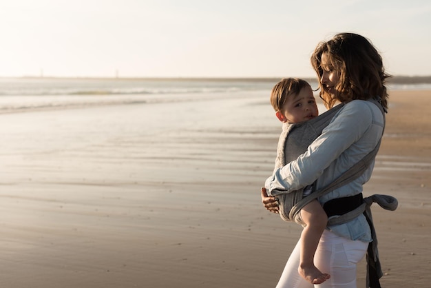 浜辺に立っている母親が息子を抱きしめている