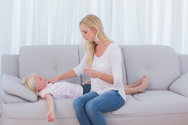 Mother checking the temperature of her daughter