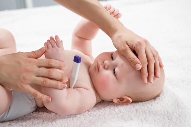 Mother checking temperature of her ill kid