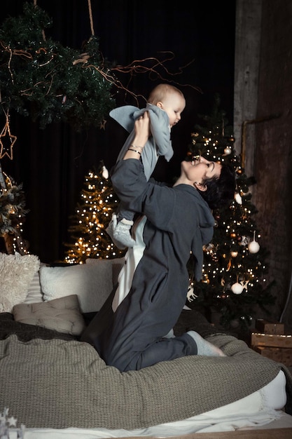 mother and child boy on the background of the Christmas tree in kigurumi costumes