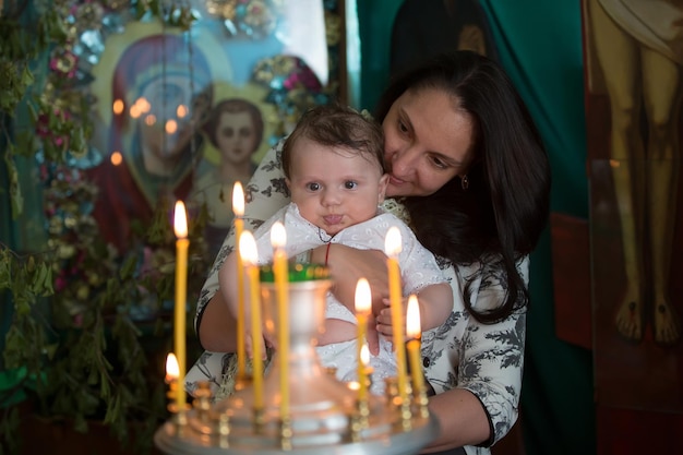 Мать и ребенок в церкви смотрят на свечи