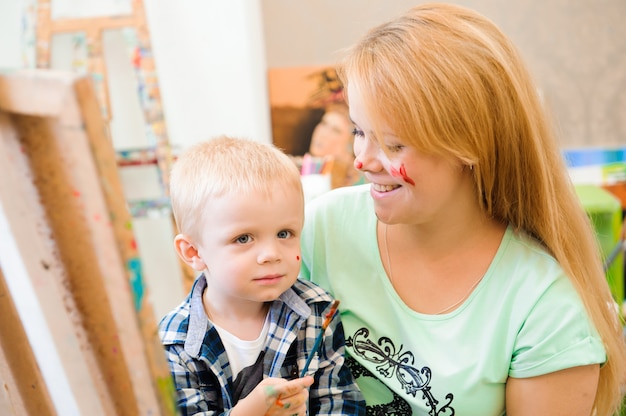 Madre e figlio disegnano una pittura, lezione d'arte