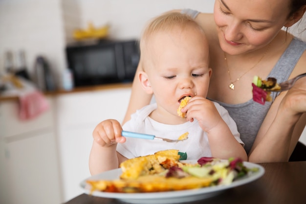 Photo mother and child eating together