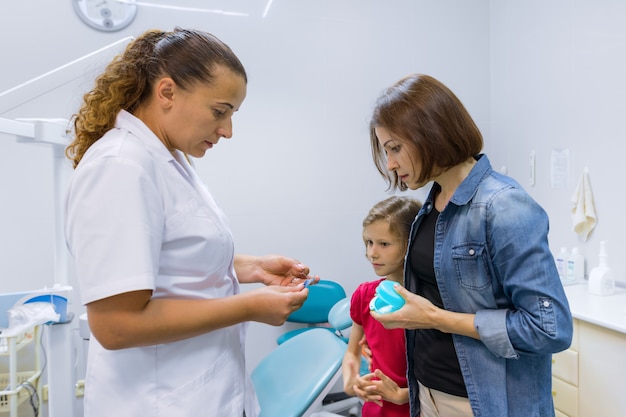 Mother and child girl in meeting with doctor orthodontist