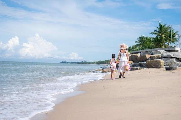 Mother and child girl relax on the beach