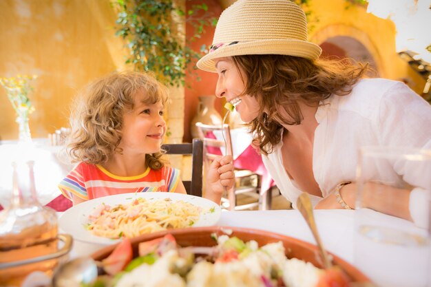 Mother and child having fun in summer cafe outdoors