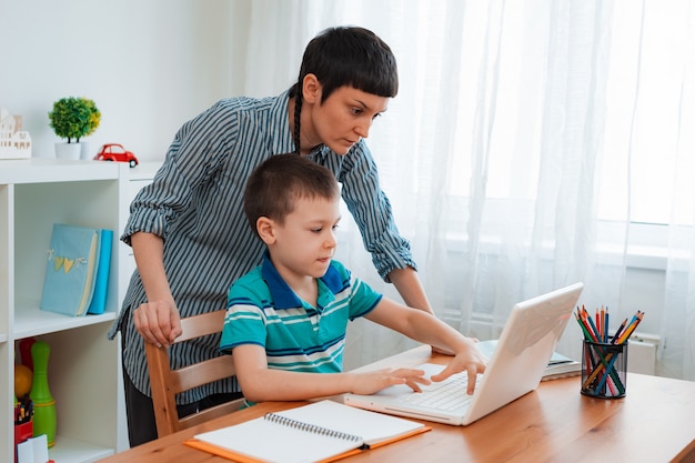 Photo mother and child at home with a laptop, learning