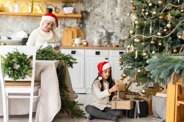 Mother and Child Hug in Front of a Christmas Tree.