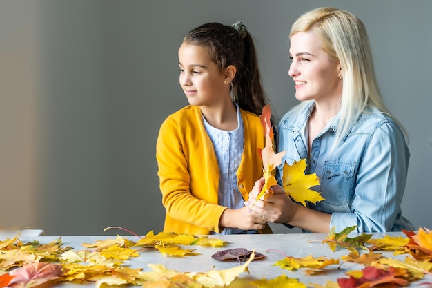 Mother and child looking on laptop sits together on leaves iat home