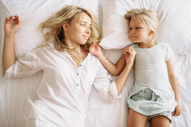 Mother and child lying on the bed, top view