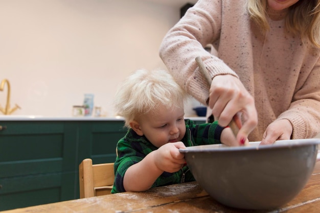 Mother and child mixing ingredients in a bowl in the kitchen together