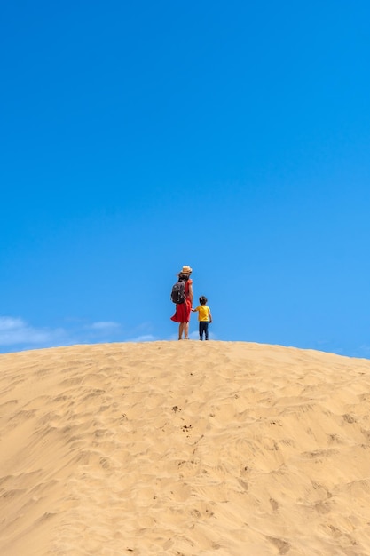 Mother and child smiling in the dunes of Maspalomas in summer Gran Canaria Canary Islands