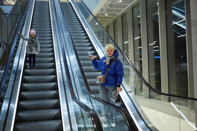 Mother and child together on escalator background Terminal airport travel love care