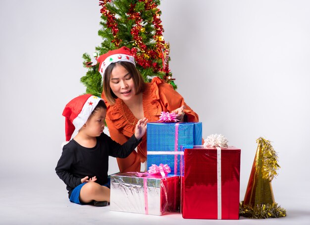 Mother and child very happy with gift a day Christmas and Happy New Year on background in studio