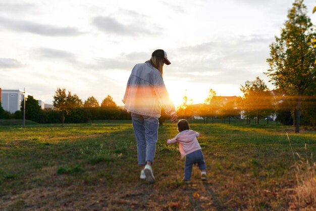 Mother and child walk in the park in the evening