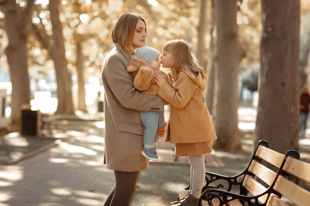 Мать и ребенок на прогулке в общественном парке обнимаются и целуются