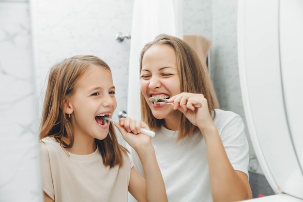 Photo mother and children brush their teeth in the bathroom