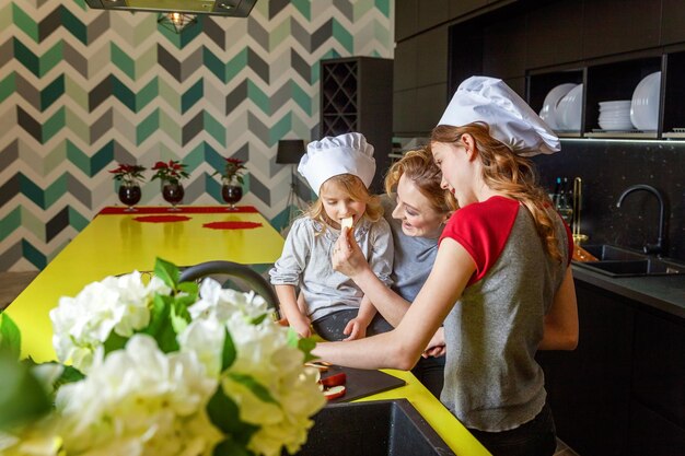 Mother and children cooking in kitchen and having fun