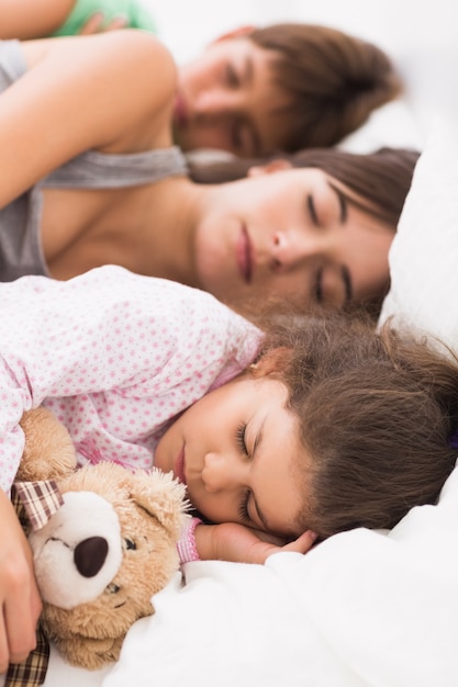 Foto madre e figli coccolati a letto