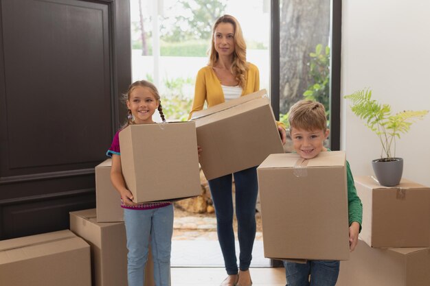 Photo mother and children holding cardboard boxes in a comfortable home