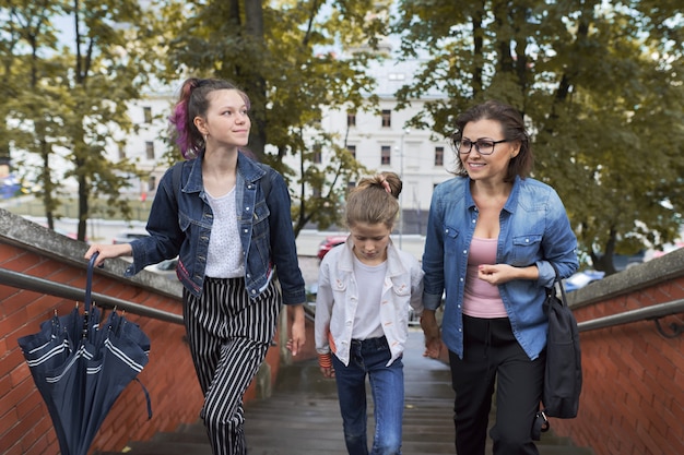 Mother and children two daughters walking on the stairs