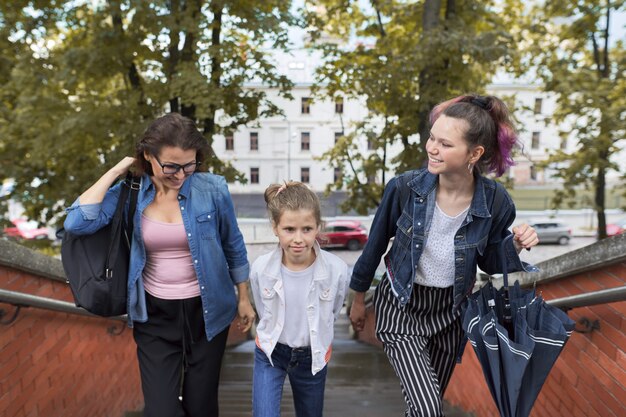 Mother and children two daughters walking on the stairs