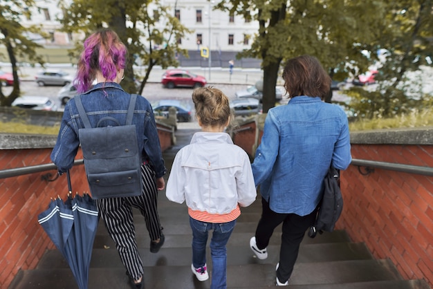 Mother and children two daughters walking on the stairs