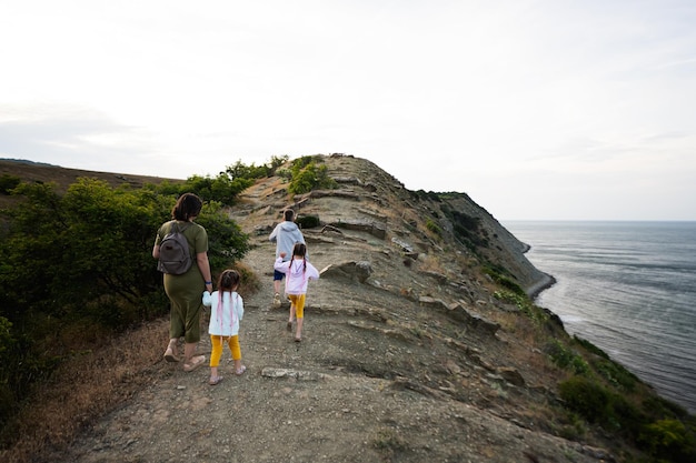 Mother and children walking on a cliff by the sea back view Cape Emine Black sea coast Bulgaria