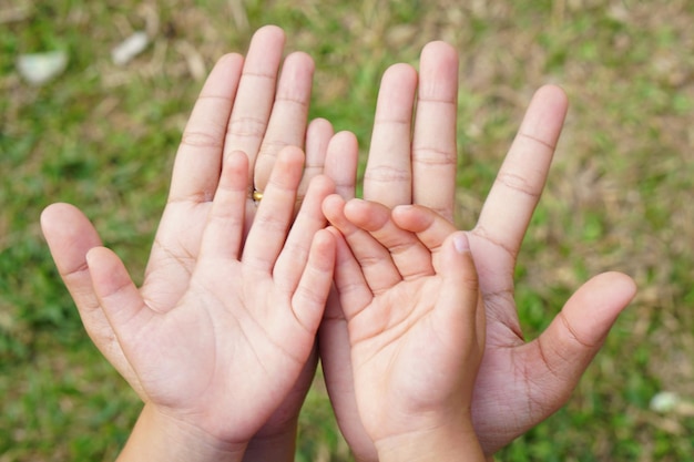 Foto madre e bambino si tengono per mano per ricevere qualcosa