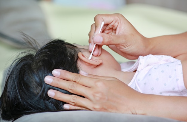 Mother Cleaning Baby Ear With cotton swab.