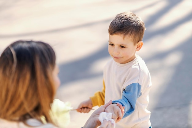 ウェットティッシュで息子の手を拭く母親