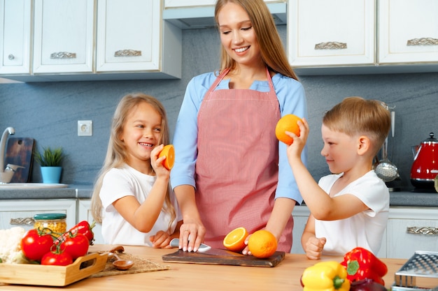 Photo mother cooking with her children in kitchen