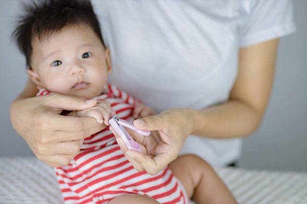 mother cutting little baby fingers nails