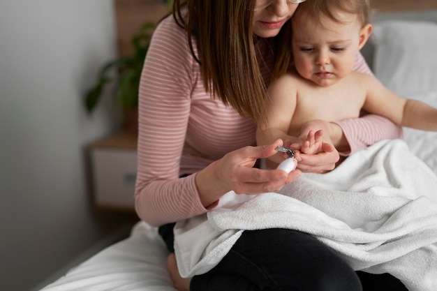 Mother cutting nails of baby