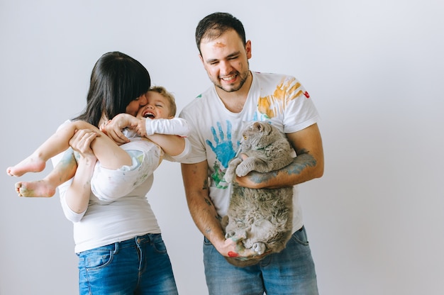 mother dad son and cat on a white background after playing paint