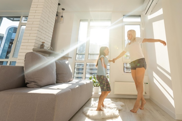 Mother dancing with daughter in the room