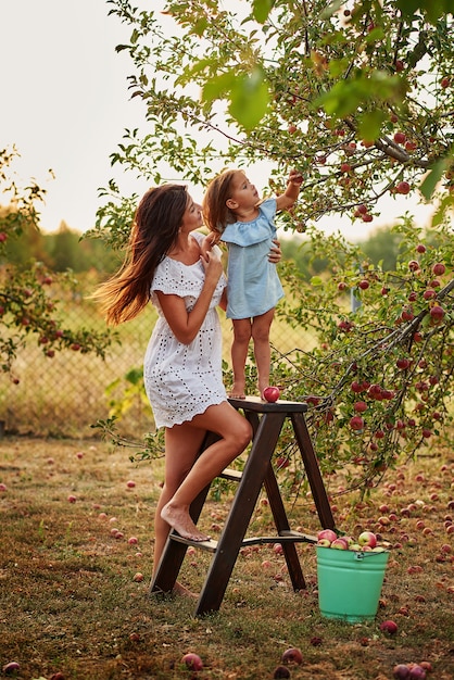 Mother and daughter in apple garden