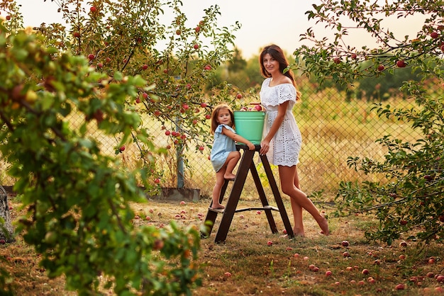 Mother and daughter in apple garden