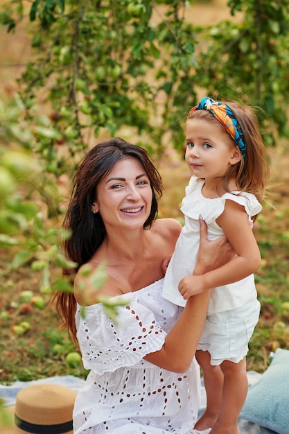 Mother and daughter in apple garden