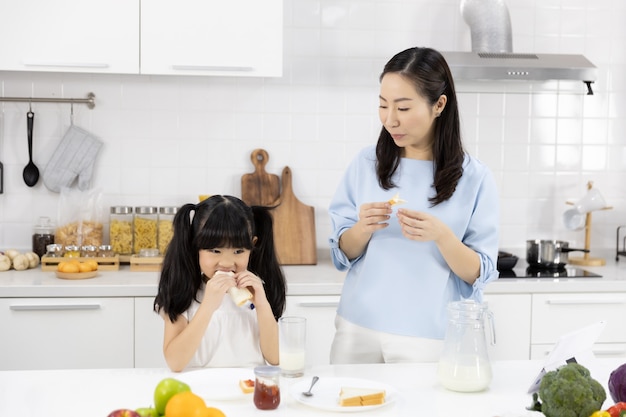 母と娘は台所で朝食を食べています