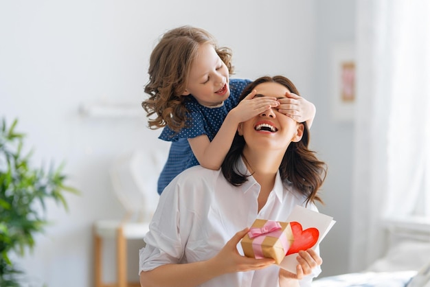 Foto una madre e una figlia tengono in mano un regalo con su scritto 