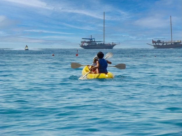 Mother and daughter are sailing on the sea in a canoe Tourist ships and a jet ski are in the background Turkey