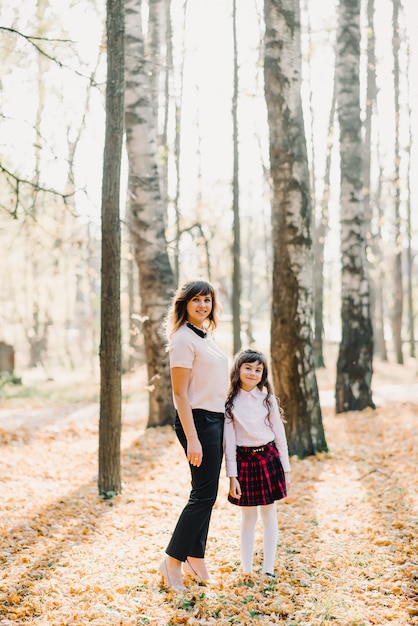 Mother and daughter autumn in park