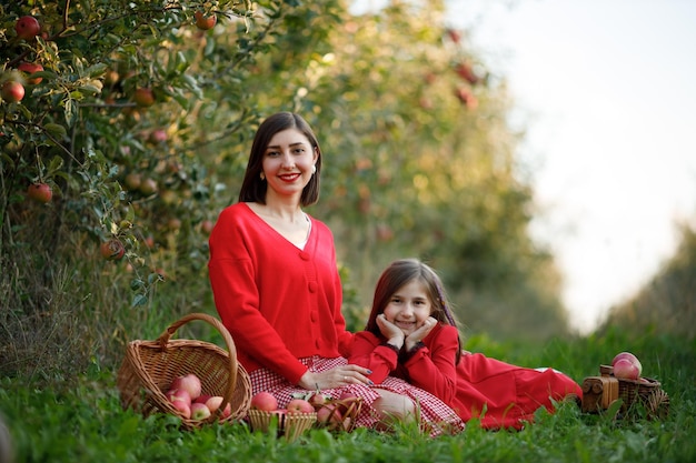 Mother and daughter on an autumn picnic in the garden the girl\
is smiling and happy in nature