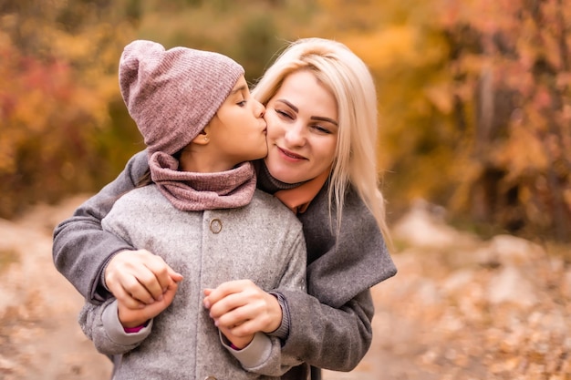 Mother and daughter in autumn yellow park.