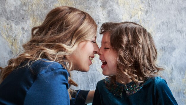 Photo mother and daughter in beautiful blue dress face to face