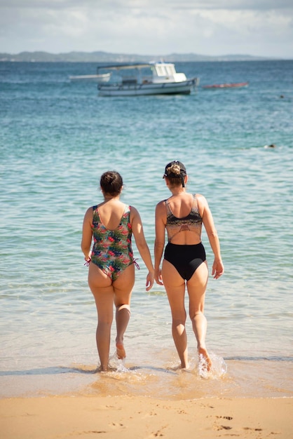 Photo mother and daughter in bikini entering the water