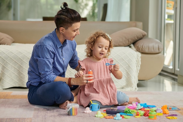 Photo mother and daughter blowing soap bubbles